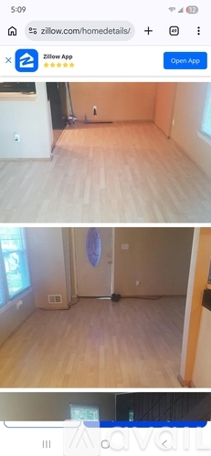 A room with wooden flooring and a round rug on the floor.