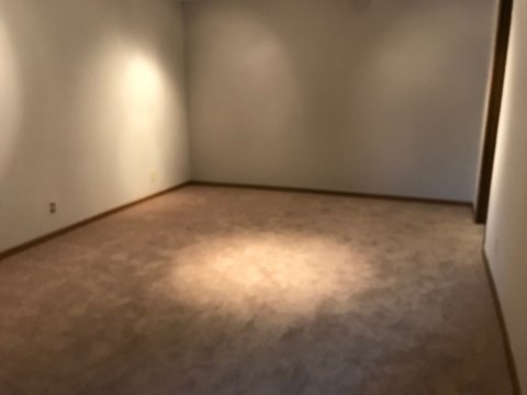 A room with a carpet and a light on the floor.