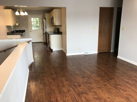 A kitchen with white cabinets and a black fridge.