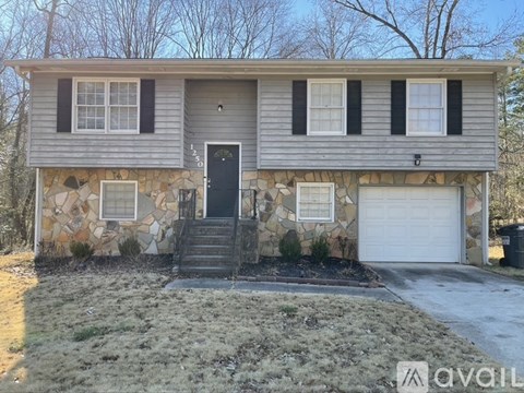 A house with a grey siding and a black door is for sale.
