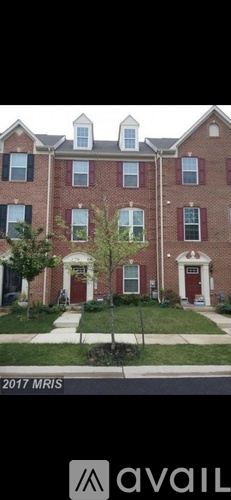 A red brick building with white trim and a tree in front.