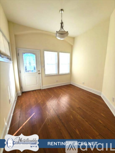 A room with wooden floors and a white door.