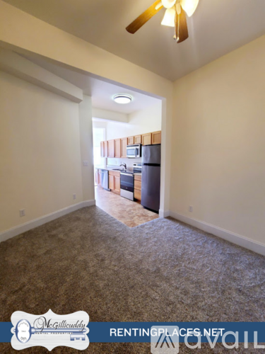 A room with a ceiling fan and a carpeted floor.