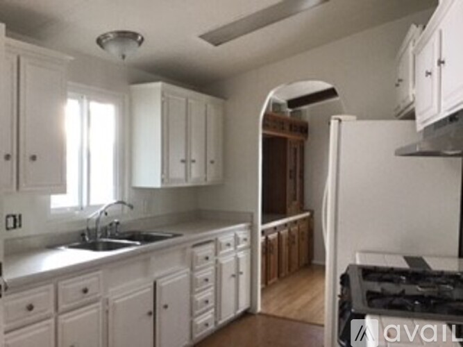 A kitchen with white cabinets and a sink.