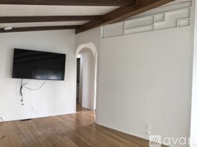 A living room with a flat screen TV mounted on the wall.