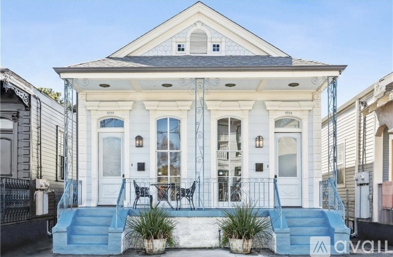 A white house with a blue staircase.