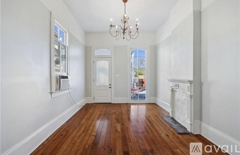 A room with wooden floors and a chandelier.