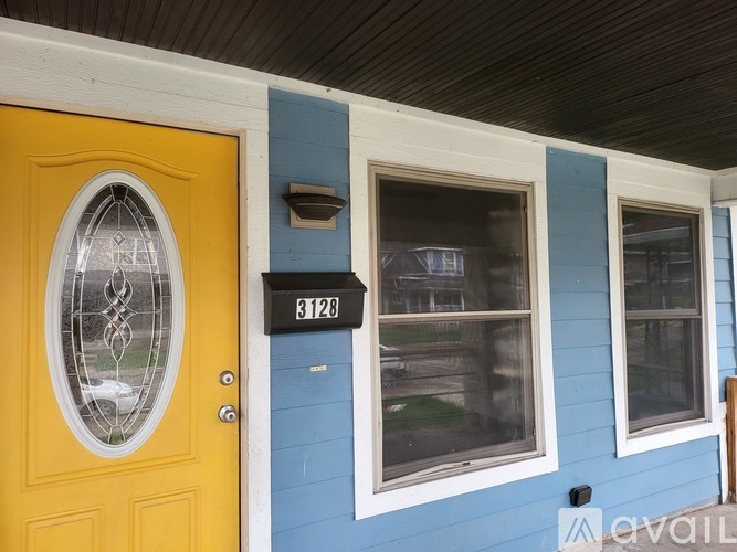 A yellow door with a glass window above it and a mailbox on the wall.