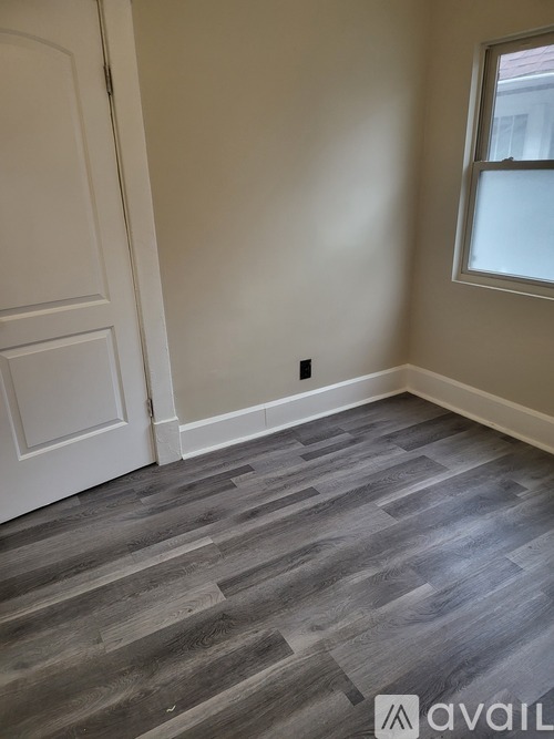 A room with a wooden floor and a white door.