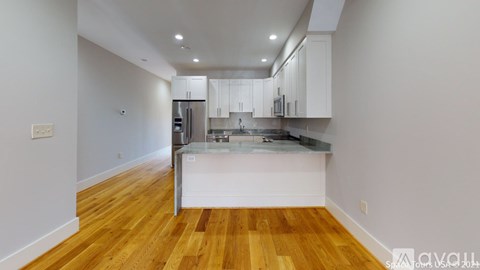 A kitchen with wooden floors and white walls.