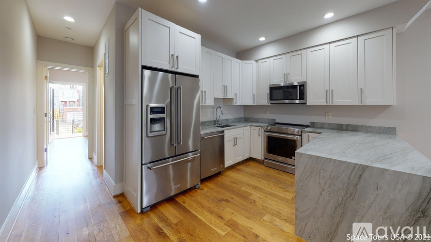 A kitchen with wooden floors and stainless steel appliances.