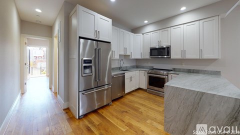 A kitchen with wooden floors and stainless steel appliances.