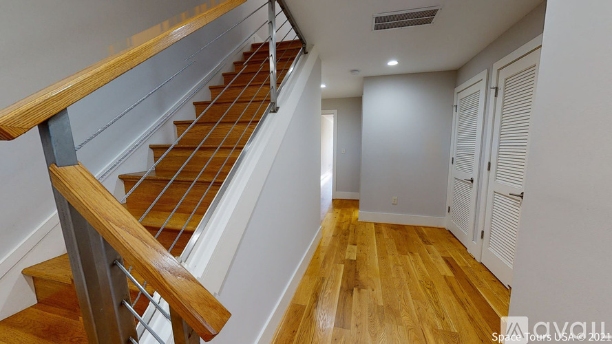 A wooden staircase with a metal railing.