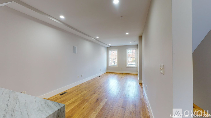 A spacious room with wooden floors and a marble countertop.