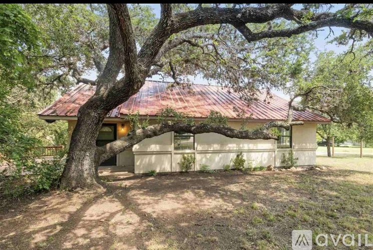 A house with a red roof is surrounded by trees.