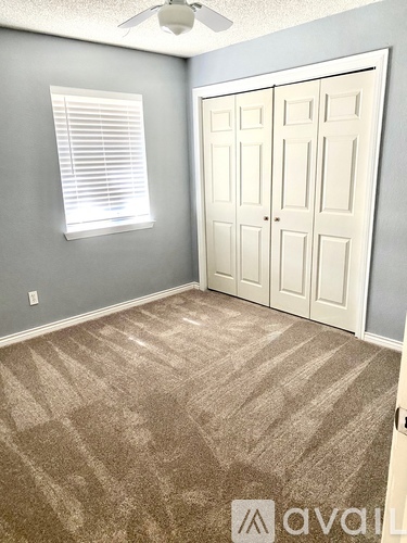 A room with a carpeted floor and a white door.