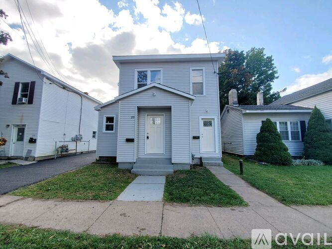 A house with a white door and a grey roof is for sale.