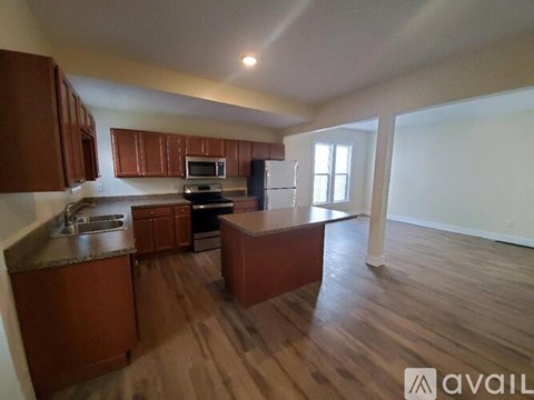 A kitchen with wooden cabinets and a refrigerator.