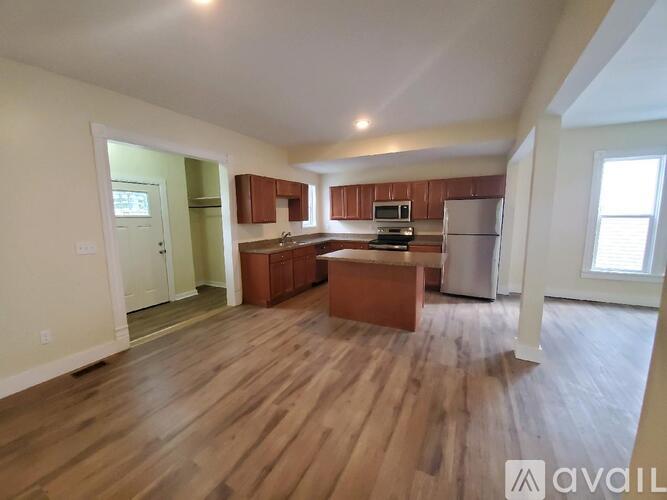 A kitchen with wooden floors and a refrigerator.