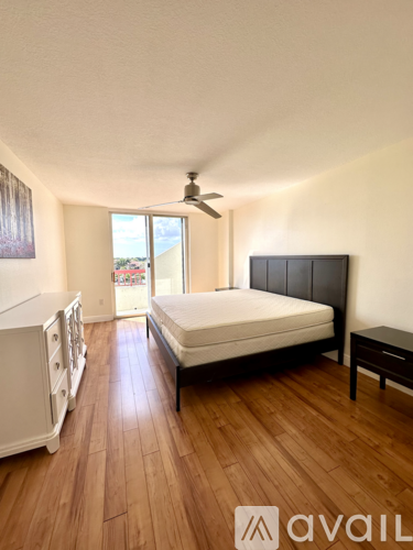 A bedroom with a bed, dresser, and ceiling fan.