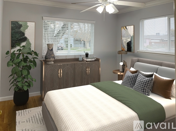 A bedroom with a bed, a plant, and a fan.