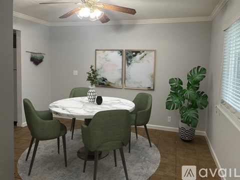 A dining room with a round table and chairs.