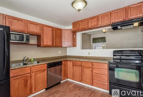 A kitchen with wooden cabinets and a black stove top oven.