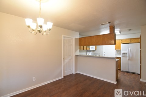 A kitchen area with a white counter and a chandelier hanging from the ceiling.