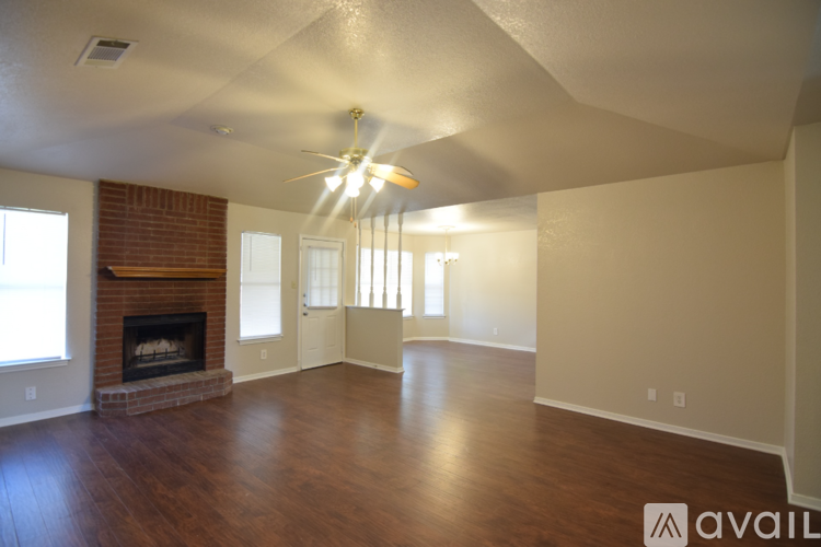 A living room with a fireplace and a ceiling fan.