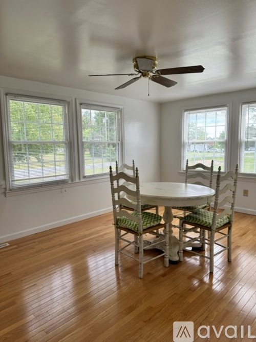 A dining room with a table and chairs.