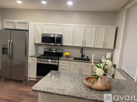 A kitchen with a granite countertop and white cabinets.