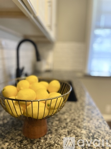 A bowl of lemons sits on a granite countertop.