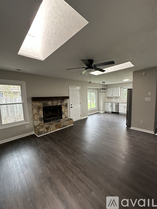A spacious living room with a fireplace and hardwood floors.