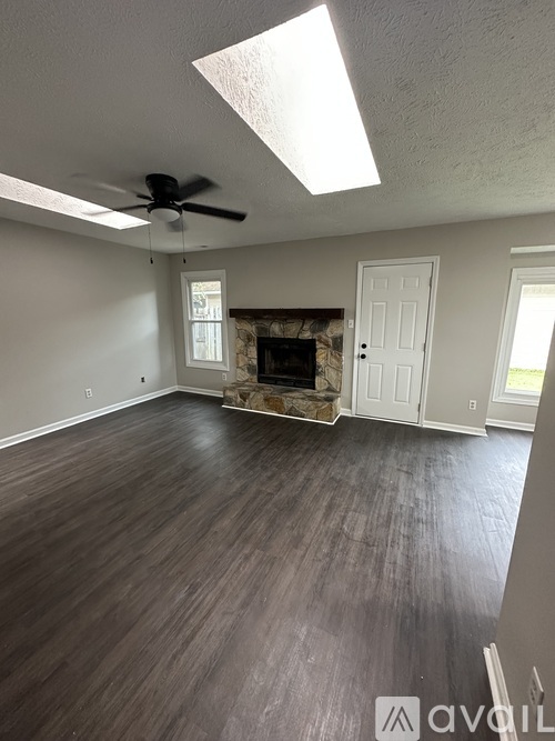 A room with a fireplace and a ceiling fan.