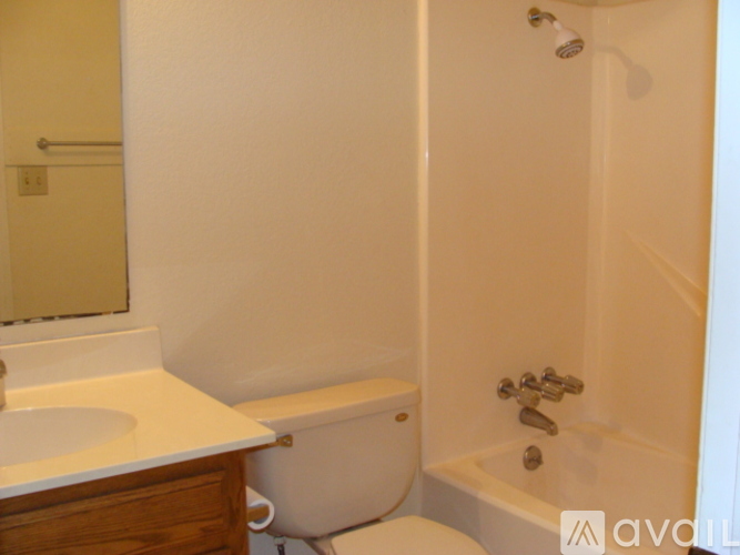A white bathroom with a tub, sink and mirror.
