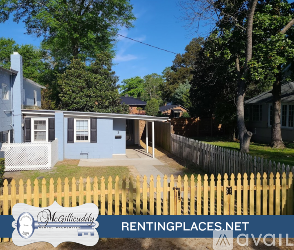 A blue house with a white fence and a sign that says McGillicuddy RENTINGPLACES.NET.