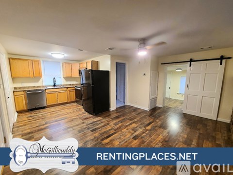 A kitchen with wooden floors and a black refrigerator is on the market.