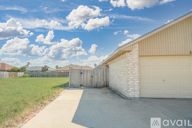 A sunny day at a residential area with a clear blue sky and a few clouds.
