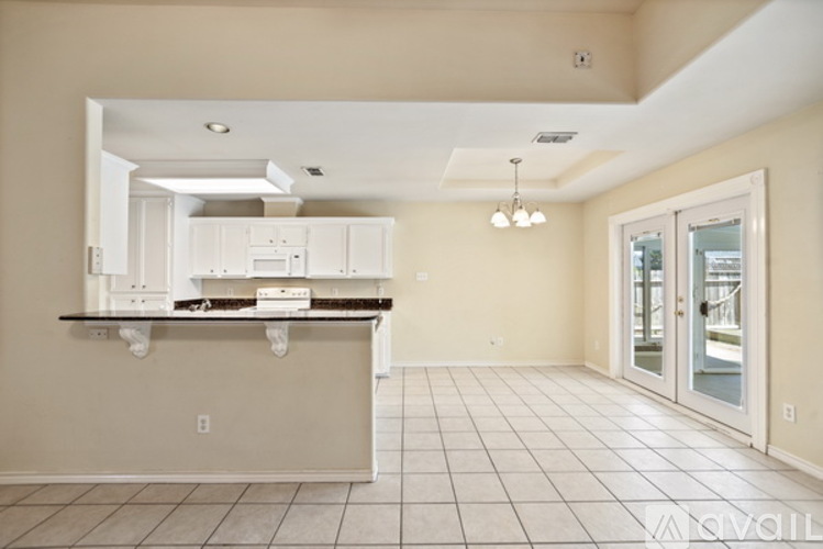A kitchen with white cabinets and a black countertop.