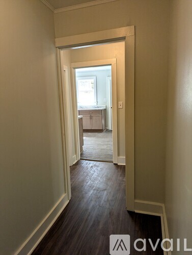 A hallway with a doorway leading to a bedroom.
