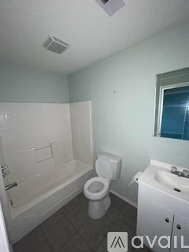 A bathroom with a toilet, sink, and bathtub.