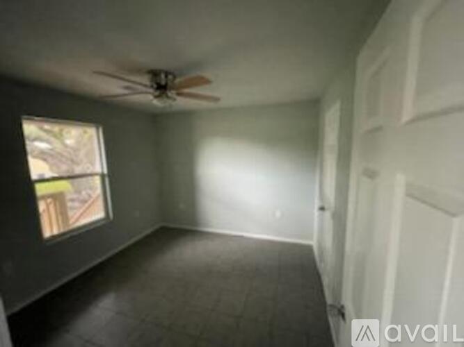 A room with a ceiling fan and a window.