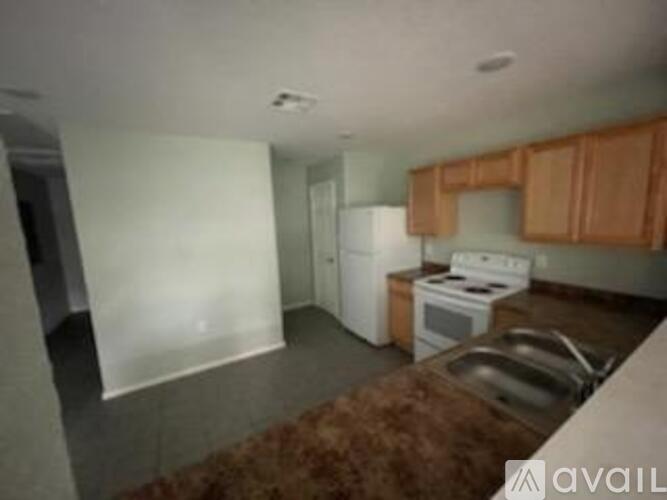 A kitchen with a white fridge and stove top oven.