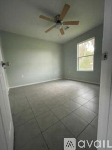 A room with a ceiling fan and tile flooring.