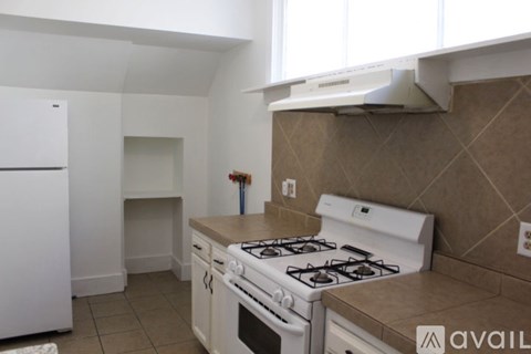 A kitchen with a white stove and a white fridge.