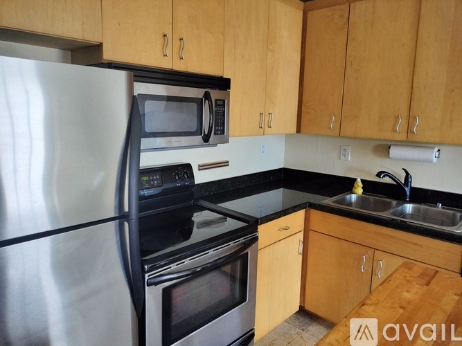 A kitchen with wooden cabinets and a black countertop.