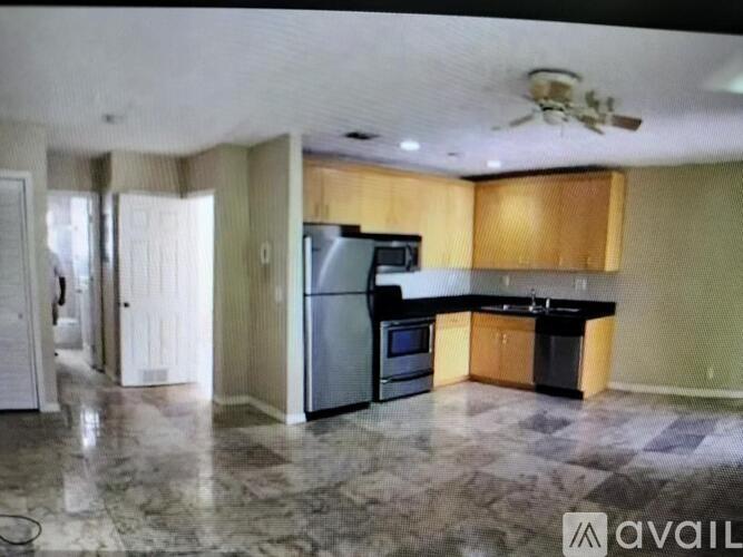 A kitchen with a refrigerator, microwave, and oven.