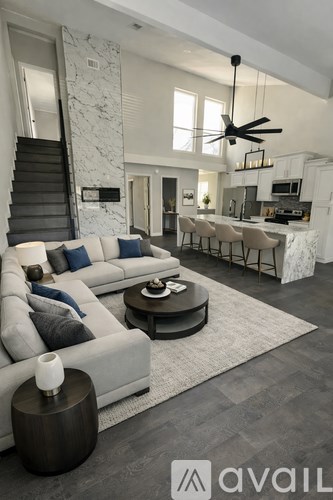 A modern kitchen with a marble island and pendant lights.