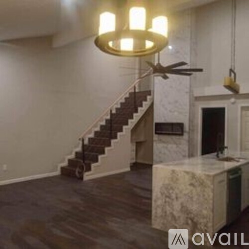 A staircase with a metal railing and a chandelier hanging from the ceiling.