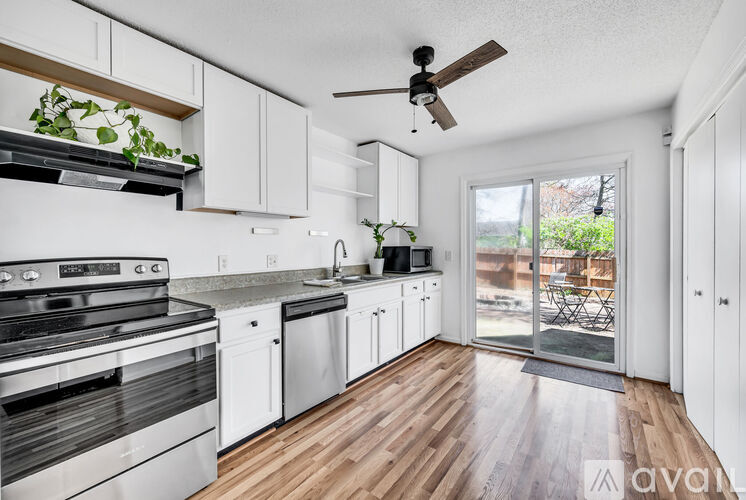 A kitchen with white cabinets and a wooden floor.